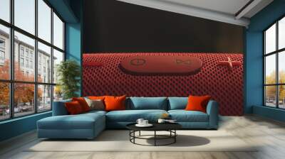 Wireless music speaker. Red Bluetooth speaker. Control and volume buttons. Wall mural