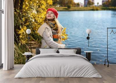 Autumn portrait of young pretty girl in red hat Wall mural