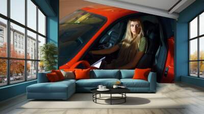 pretty young girl sits behind the wheel Wall mural