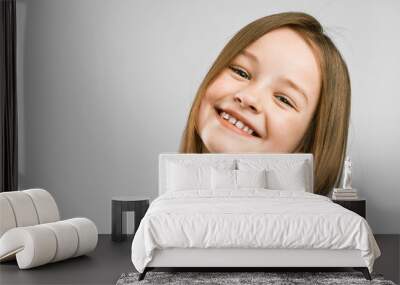 studio portrait of a cute little girl on a gray background. kid smiling Wall mural