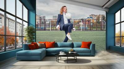 woman soccer player in an office suit stuffs the ball with her head. concept Wall mural