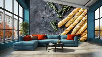 A batch of homemade grissini breadsticks, lightly sprinkled with sea salt and rosemary, arranged on a rustic surface for a simple yet flavorful snack. Wall mural