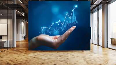 A hand holds a chart with a growing up arrow and a graph of stock market or business growth on a virtual screen  Wall mural