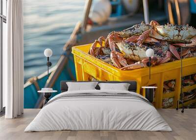 A yellow plastic crate full of crabs sits on the deck of an old-fashioned fishing boat in the harbor. Wall mural