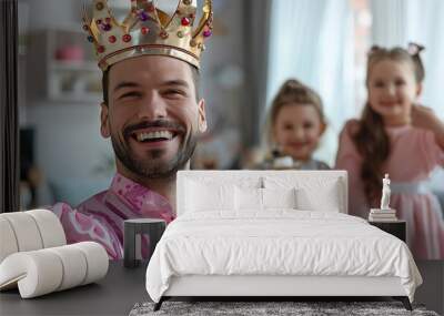 cheerful happy adult man wearing princess costume in bright living room, cheerful two girls in background Wall mural