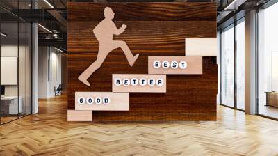 Good - Better - Best,  paper man climbing the steps to success in a conceptual image over wooden background Wall mural