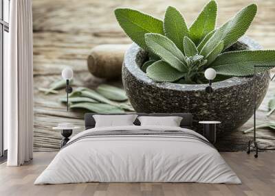 Green sage leaves and pestle in mortar on wooden table Wall mural