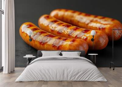 Grilled sausages glistening with savory juices sitting on a dark surface Wall mural