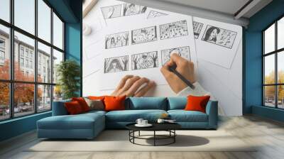 Hands of the artist draw a storyboard on paper. Storytelling. Story frames with heroes. Wall mural