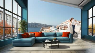 Happy couple hugging and laughing together with a view of Santorini Wall mural