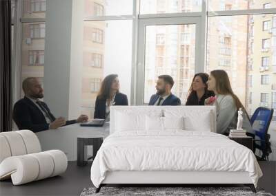 Office workers, employees of a large company, two young men and three young women discuss the firm's issues, the end of the meeting everyone talks to each other and smiles Wall mural