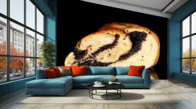 One fragrant bun with poppy seeds in a section, close-up, isolated on a black background. Wall mural