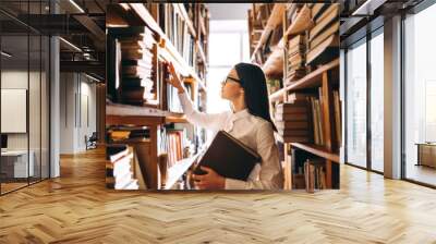 people, knowledge, education and school concept - happy student girl with book in library Wall mural