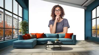 Portrait of a pensive Indian girl on a white isolated background. Young smiling woman in glasses is thinking about an idea.  Wall mural