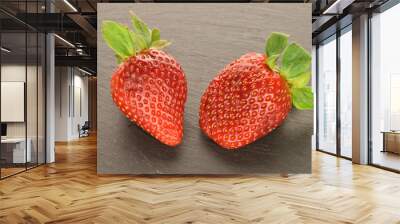 Two berries of bright red ripe organic delicious strawberries on a serving plate of slate. Wall mural