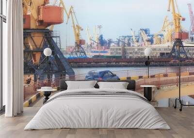 Blue passenger car in the seaport on the background of cranes after unloading. Freight transportation, shipment and delivery  import export concept. Wall mural