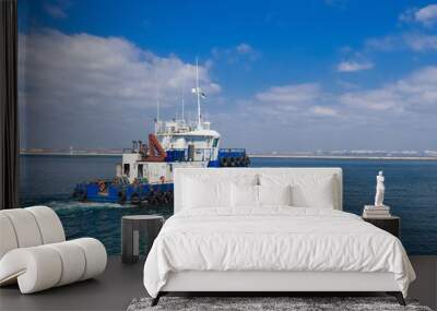 towing ship in the open sea, blue tugboat sailing on sea water against the sky. Sea port of Odessa, Ukraine Wall mural