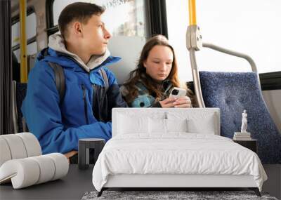 two teenagers in blue clothes sit on bus Canada Vancouver hoods autumn winter spring tracksuits use a mobile phone search for geolocation travel travelers real life Wall mural