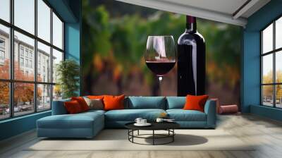 A glass of red wine with a bottle on the background of blurred vineyards. Generative AI Wall mural