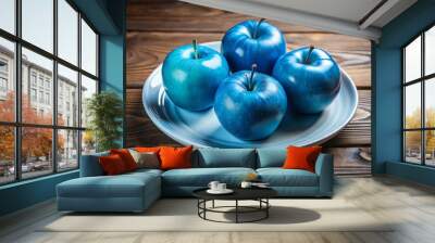 blue apples on a white plate which is on a wooden table Wall mural