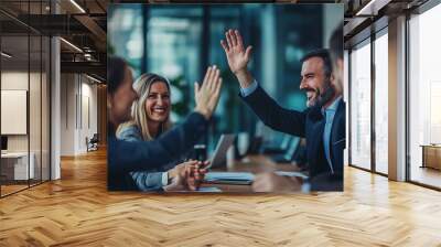 Businesswoman giving a high five to male colleague in meeting. Business professionals high five during a meeting in boardroom. Wall mural