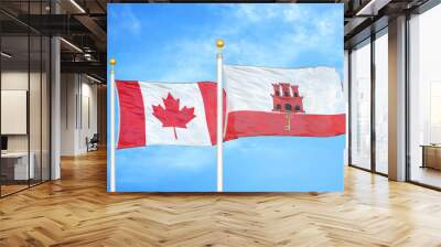 Canada and Gibraltar two flags on flagpoles and blue cloudy sky Wall mural