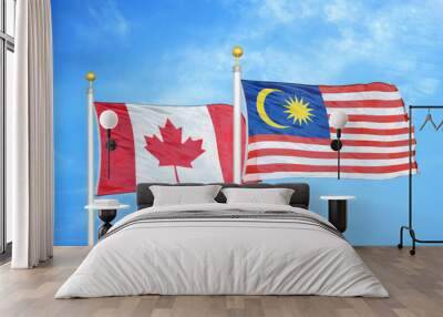 Canada and Malaysia two flags on flagpoles and blue cloudy sky Wall mural