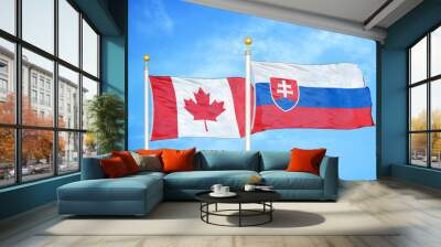 Canada and Slovakia two flags on flagpoles and blue cloudy sky Wall mural