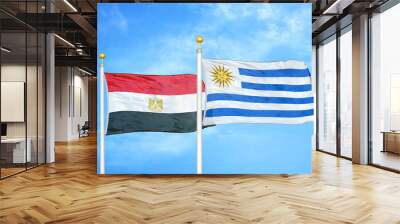 Egypt and Uruguay two flags on flagpoles and blue cloudy sky Wall mural