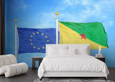 European Union and French Guiana two flags on flagpoles and blue cloudy sky Wall mural