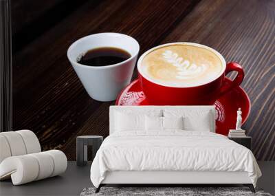 Coffee in a red cup with milk and latte art and coffee in a white cup on a table Wall mural