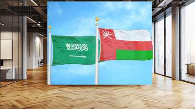 Saudi Arabia and Oman two flags on flagpoles and blue cloudy sky Wall mural