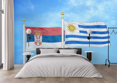 Serbia and Uruguay two flags on flagpoles and blue sky Wall mural