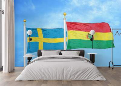 Sweden and Bolivia two flags on flagpoles and blue sky Wall mural