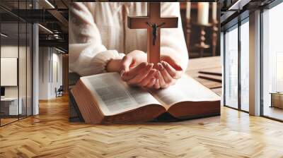 Female god believer holding wooden cross on opened holy bible book at light wooden church table. Top view. Concept of hope, religion, faith, christianity and god blessing. Warm background. Burgeoning Wall mural