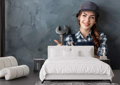 Female plumber with wrench showing thumb-up on grey background Wall mural