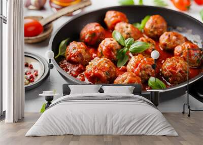 Frying pan of tasty meat balls with tomato sauce and basil on white background Wall mural