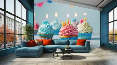 Happy Birthday. Colorful cupcakes with candles on light blue background Wall mural