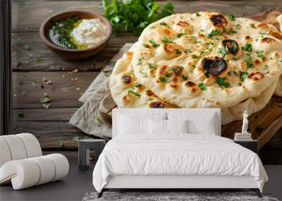 Indian naan bread on wooden board on light wooden table Wall mural