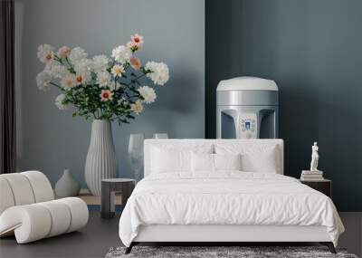 Modern water cooler and vase with flowers on end table near grey wall Wall mural