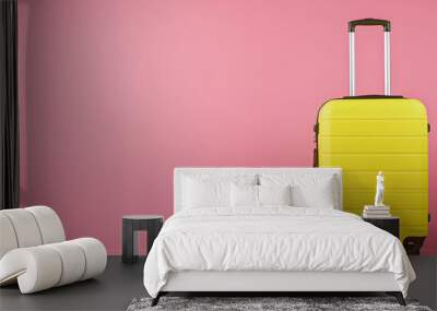 One new yellow suitcase on pink background, space for text Wall mural