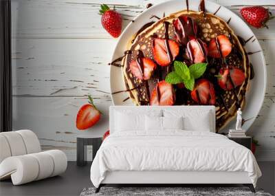 Pancakes with strawberries and chocolate decorated with mint leaf on white wooden table. Top view Wall mural