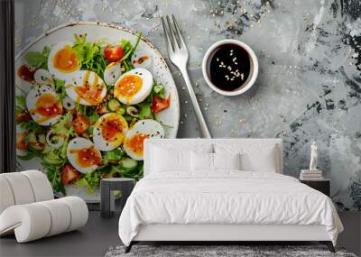 Plate of tasty salad with boiled quail eggs, soy sauce and fork on grey background Wall mural