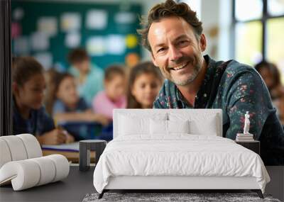 Portrait of smiling male teacher in a class at elementary school looking at camera with learning students on background Wall mural