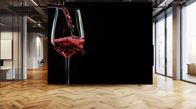 Pouring red wine into a wine glass on a black background Wall mural