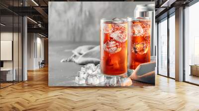 Tasty energy drink with ice cubes in glasses and aluminium cans on grey table, closeup Wall mural