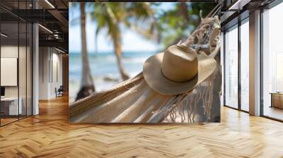 view of nice hammock hanging between two palms with some hat in it over blur ocean background sunny summer day Wall mural