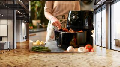 Woman hand cooking with modern Air fryer Wall mural