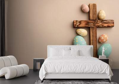 Wooden cross and painted Easter eggs on beige background Wall mural