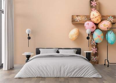 Wooden cross and painted Easter eggs on beige background Wall mural